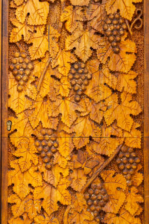 wood carving of grape leaves and grapesの写真素材