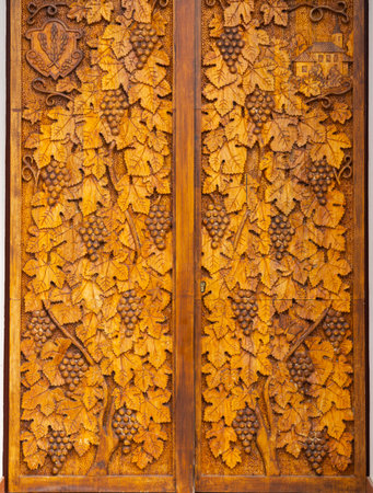 wood carving of grape leaves and grapesの写真素材