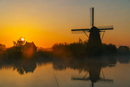 Traditional Dutch windmills with a colourful sky just before sunrise in Kinderdijk, The Netherlandsの写真素材