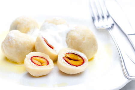 plum dumplings with sour cream, powder sugar and melted butterの写真素材