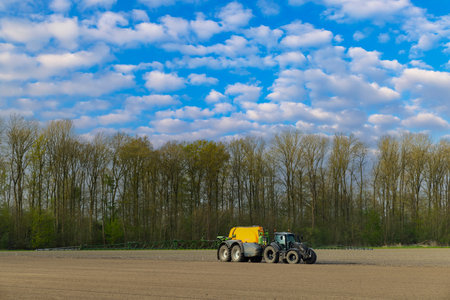 Tractor with a sprayer during spring work in the field