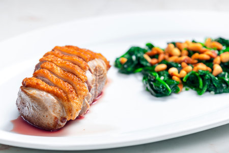 roasted duck breast served with salad of spinach leaves and pine nutsの写真素材