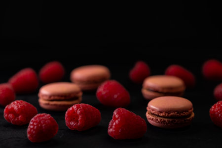 macaroons of different colors on a black backgroundの写真素材