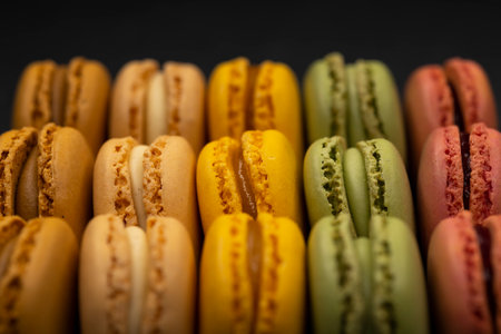 macaroons of different colors on a black backgroundの写真素材