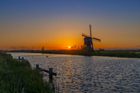 Sunset with windmill Broekmolen, Molenlanden - Nieuwpoort, The Netherlandsのeditorial素材