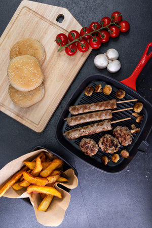 grilled meat and shasliks with mushrooms and tomatos served with french fries