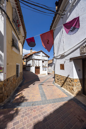 Festive medieval flags decorating a picturesque narrow street in Canete, Cuenca, Castile La Mancha, Spain, adding a touch of history and charmの写真素材