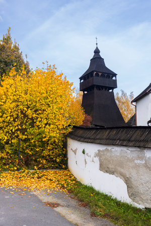 The Articulated Church of St. Margaret of Antioch with its separate wooden bell tower standing in Stara Halic, Slovakia during a beautiful autumn dayの写真素材