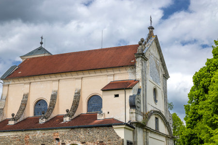 Assumption of Virgin Mary Church with red tiled roof and weathered stone walls in Nova Bystrice, Czechiaの写真素材