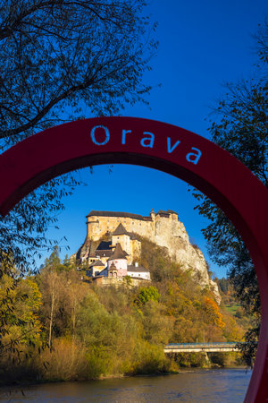 Orava Castle framed by red circular sign with its name, during a beautiful autumn day in Slovakiaの写真素材
