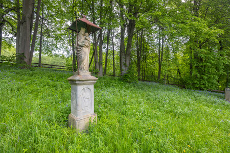 Statue of Madonna and Child stands in a green meadow in Sekowa, Lesser Poland Voivodeship, Polandの写真素材