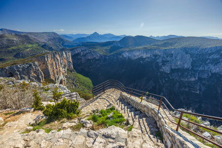 Breathtaking view of Verdon Gorge from a descending stairway with metal railing on a clear sunny dayの写真素材
