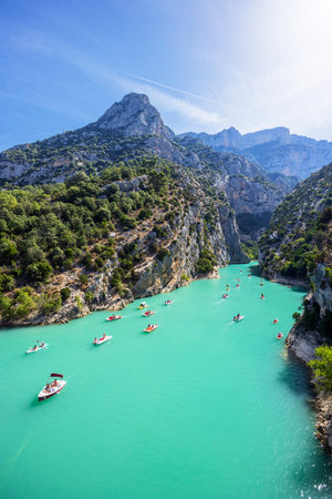 Tourists enjoying turquoise waters of the Verdon Gorge in France, paddling pedal boats and kayaks on a sunny summer dayの写真素材