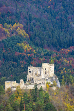 Ruins of medieval castle Lietava overlooking colorful autumn forest in Sulov Rocks, Slovakiaの写真素材