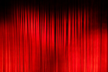 Red velvet curtain closing on a dark stage, perfect for entertainment or theatre conceptsの写真素材