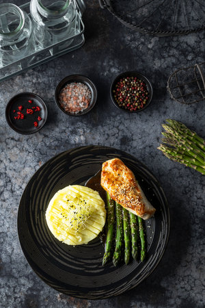 Sesame crusted chicken breast served with mashed potatoes, asparagus and gravy, healthy and balanced mealの写真素材