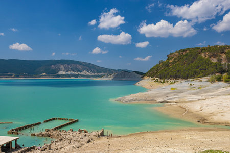 Scenic view of the Yesa reservoir with turquoise water and ruins of the old town of Sigues emerging due to low water levels, located in Aragon, Spainの写真素材