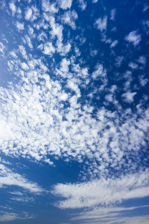 Beautiful small white clouds covering a deep blue sky on a sunny dayの写真素材