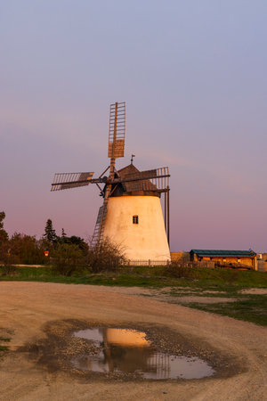 Old windmill reflecting in puddle at sunset in Retz, Lower Austria, Austriaの写真素材