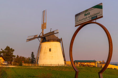 Scenic view of the windmill in Retz, Lower Austria, at sunset, with a sign highlighting the Weinviertel wine regionの写真素材
