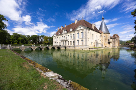 Scenic view of the historic Chateau de Commarin in Burgundy, France, reflecting in the moat on a sunny dayの写真素材