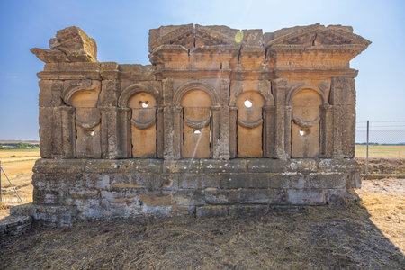 Sunlight illuminates the weathered facade of the Roman Mausoleum of the Atilii, a historical landmark in Sadaba, Spainの写真素材