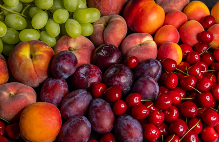 Fresh peaches, plums, cherries and grapes creating a colorful summer fruit assortment