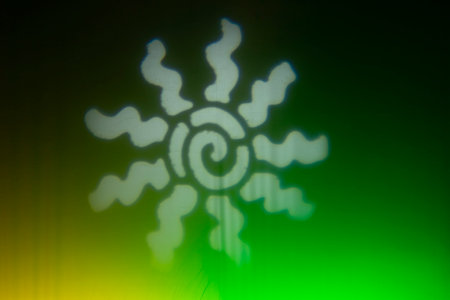 White sun symbol projected over green and yellow background