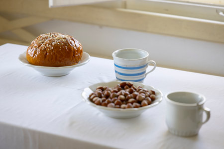Sweet bread, hazelnuts and milk served for breakfast on white tablecloth in Kourim, Czechia