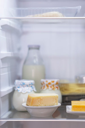 Open refrigerator containing fresh dairy products such as milk, yogurt and cheese, concept of healthy eatingの写真素材
