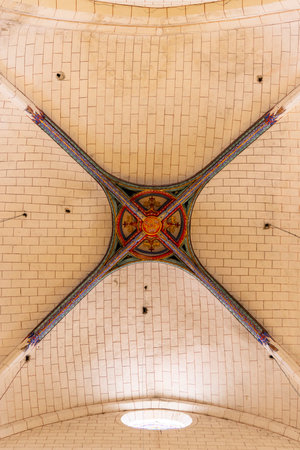 Low angle view of a colorful ribbed vault ceiling forming a cross in the Abbey of Saint Jean de Sorde, a benedictine monastery located in Sorde l'Abbaye, Landes, Nouvelle Aquitaine, Franceの写真素材