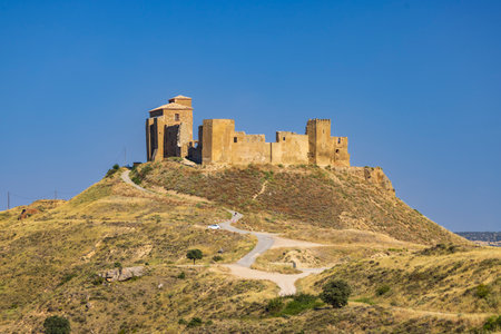 Scenic view of the Castillo de Montearagon, a historic castle located in Quicena, Huesca, Aragon, Spain, dominating the landscape under a clear blue skyの写真素材