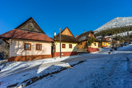 Traditional wooden houses standing along a snowy road in Vlkolinec, a UNESCO World Heritage site in Slovakiaの写真素材