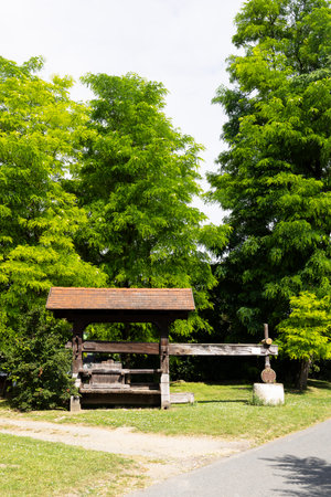 Traditional wooden wine press in Hadres, Lower Austria, Austria, surrounded by lush green trees, showcasing the region's winemaking heritageの写真素材