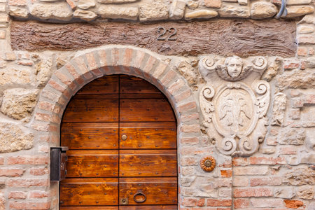Vintage wooden door framed by stone with ornate carvings and number 22の写真素材