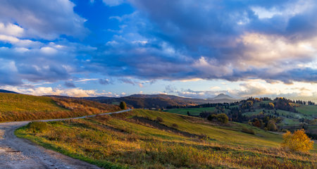 Scenic view of rolling hills bathed in warm sunset light, showcasing the beauty of autumn in the Slovak countrysideの写真素材