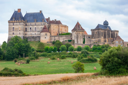 Scenic view of the Chateau de Bourdeilles rising above rolling hills and fields in the Dordogne region of Franceの写真素材