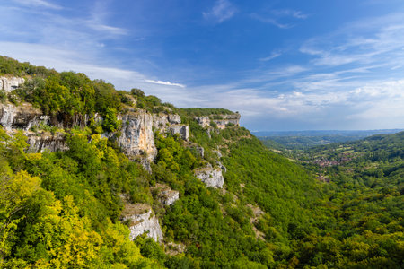 Breathtaking view of limestone cliffs overlooking a green valley with a small village in Autoire, Lot, Occitanie, Franceの写真素材