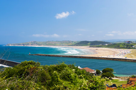 Vibrant beach scene with coastline and lush greenery in Cantabria, Spainの写真素材