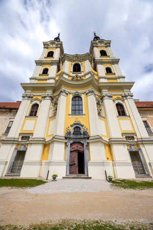 Majestic Baroque facade of Jasov Monastery under a cloudy skyの写真素材