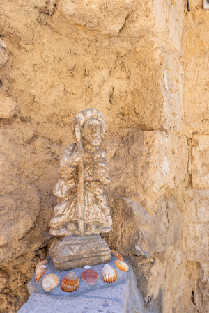 Weathered statue of saint james holding walking stick decorated with seashells, located in castrojeriz on the camino de santiago, spainの写真素材