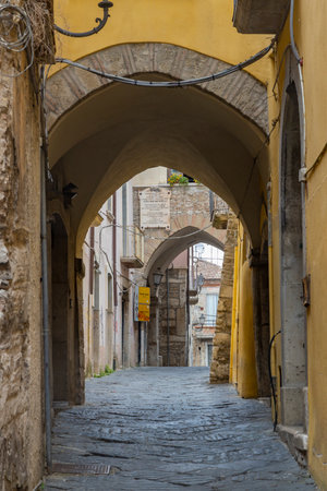 Cobblestone alley passing under arches in the historic center of Benevento, Campania, Italyの写真素材