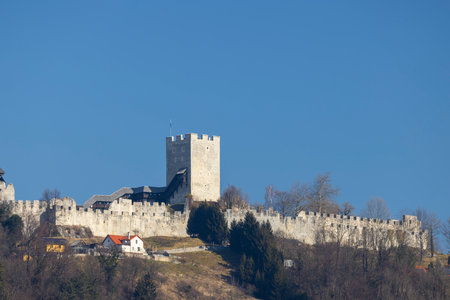 Celje Castle stands prominently against a clear blue skyの写真素材