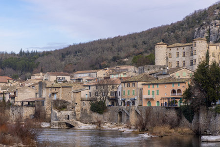 Panoramic view of Vogue, a picturesque village nestled along the Ardeche river in Auvergne Rhone Alpes, France, showcasing its medieval architecture and serene riverside settingの写真素材