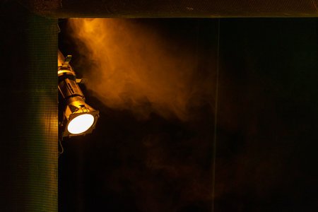 Spotlight illuminates smoke, creating dramatic shadowsの写真素材