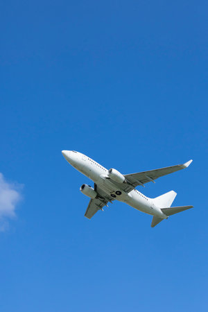 Airplane soaring in clear blue sky over Hostiviceの写真素材