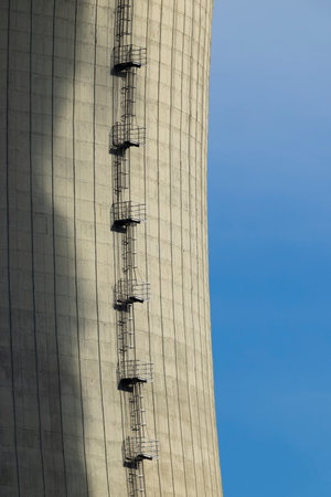 Tall concrete structure featuring a metal staircase under blue skyの写真素材