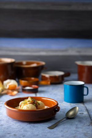 Traditional Czech potato dumplings filled with smoked meat, served with braised sauerkraut and fried onions in a rustic countryside style.の写真素材