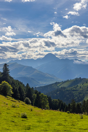 Breathtaking landscape of lush green valley and towering peaks under a cloudy sky in the French Pyreneesの写真素材