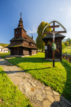 Majestic wooden church with a towering spire and a crucifix standing tall in Slovakia, showcasing historical architecture and religious significanceの写真素材